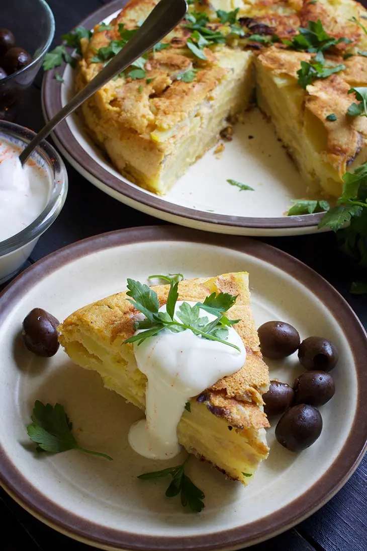 healthy Vegan Potato Tortilla slice served with cream and olives