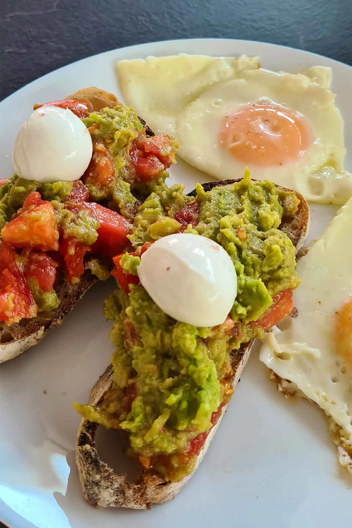 Guacamole toast with mozzarella di buffala and sunny side up eggs toast cu guacamole, mozzarella de bivolita si oua ochiuri