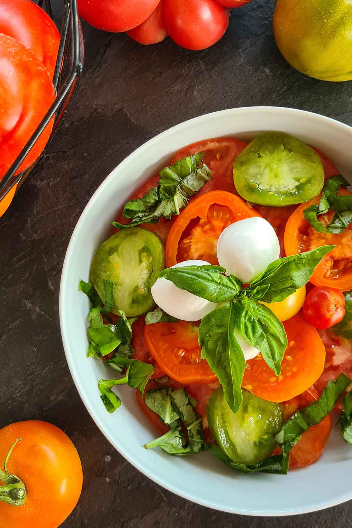 Ripe sliced tomatoes with basil pesto in a bowl