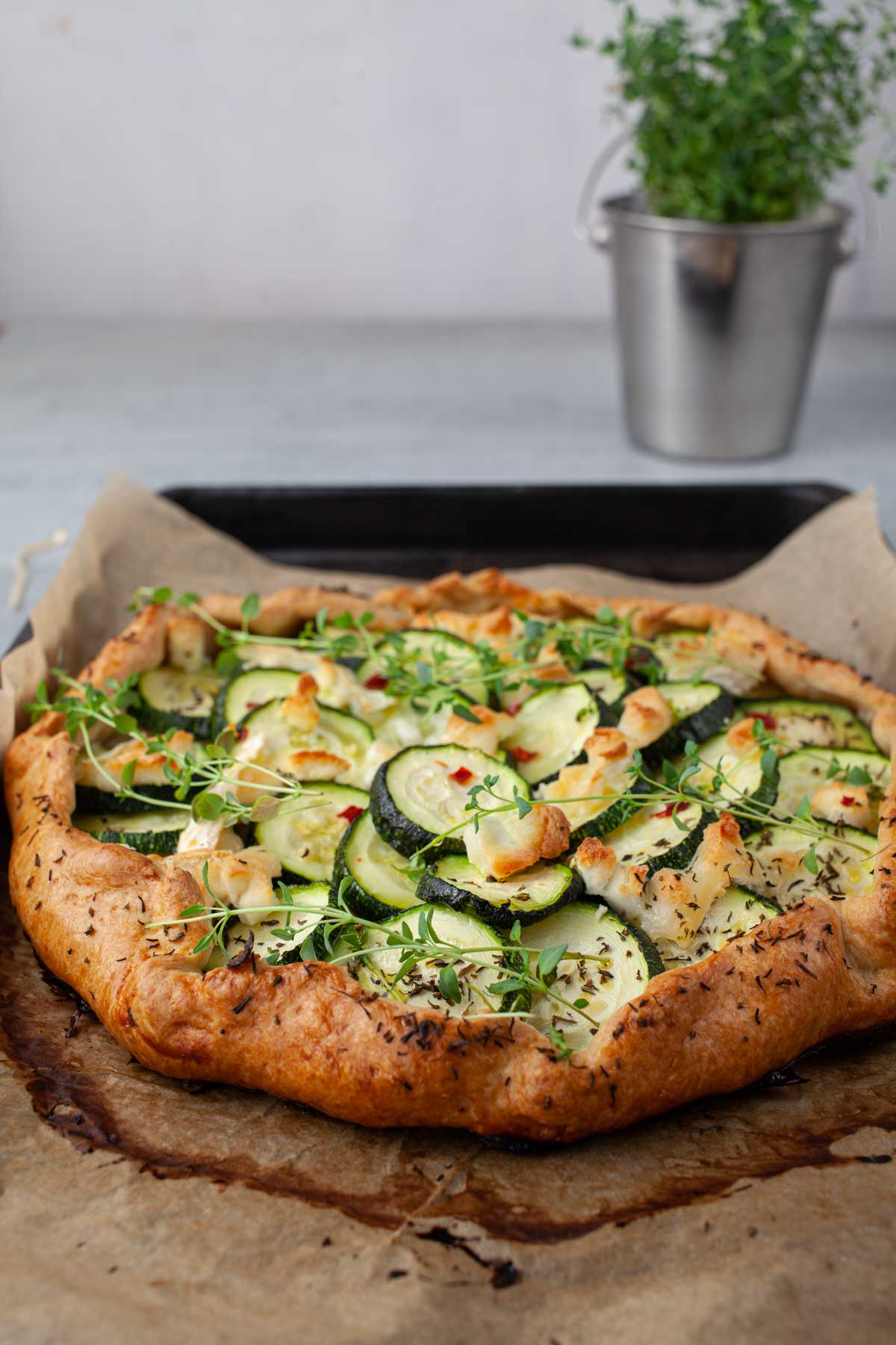 Golden baked zucchini galette with goat cheese, whole on parchment