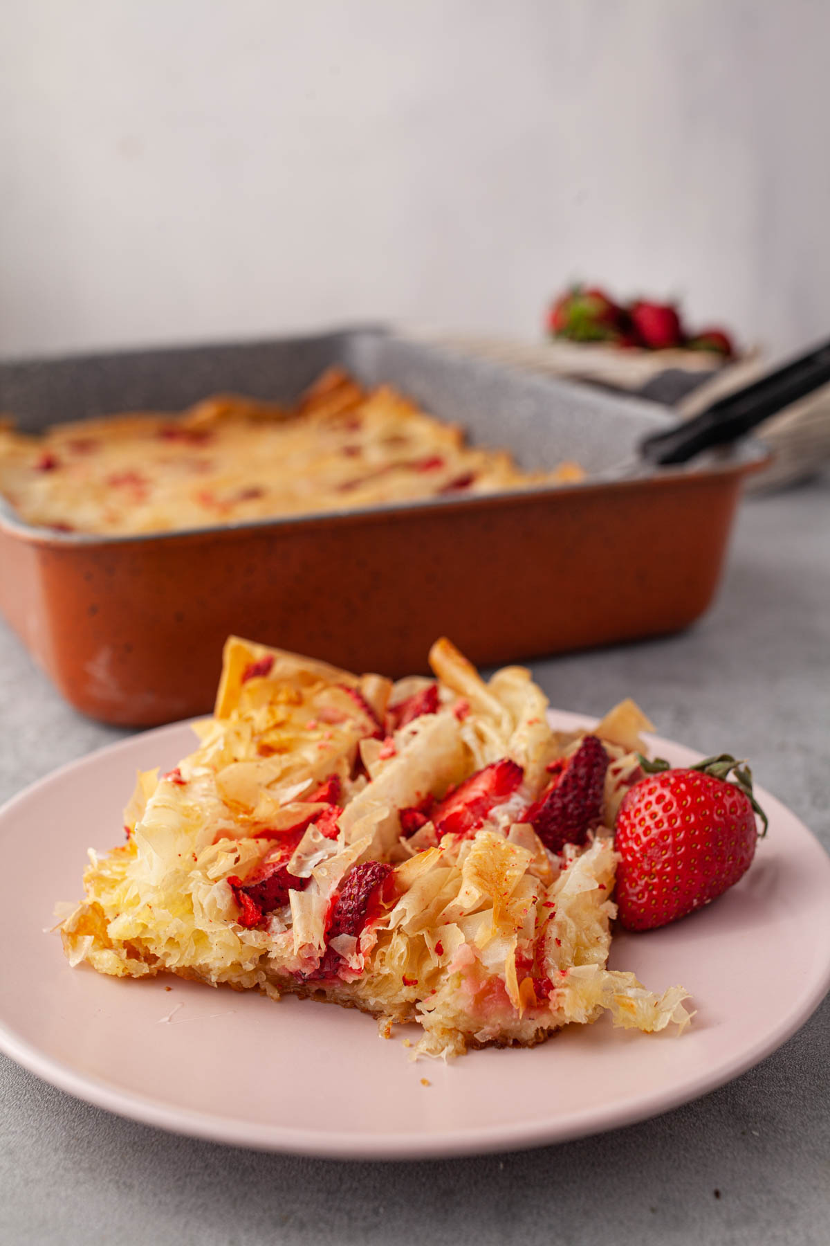 Slice of strawberry phyllo crinkle pie with custard and berries
