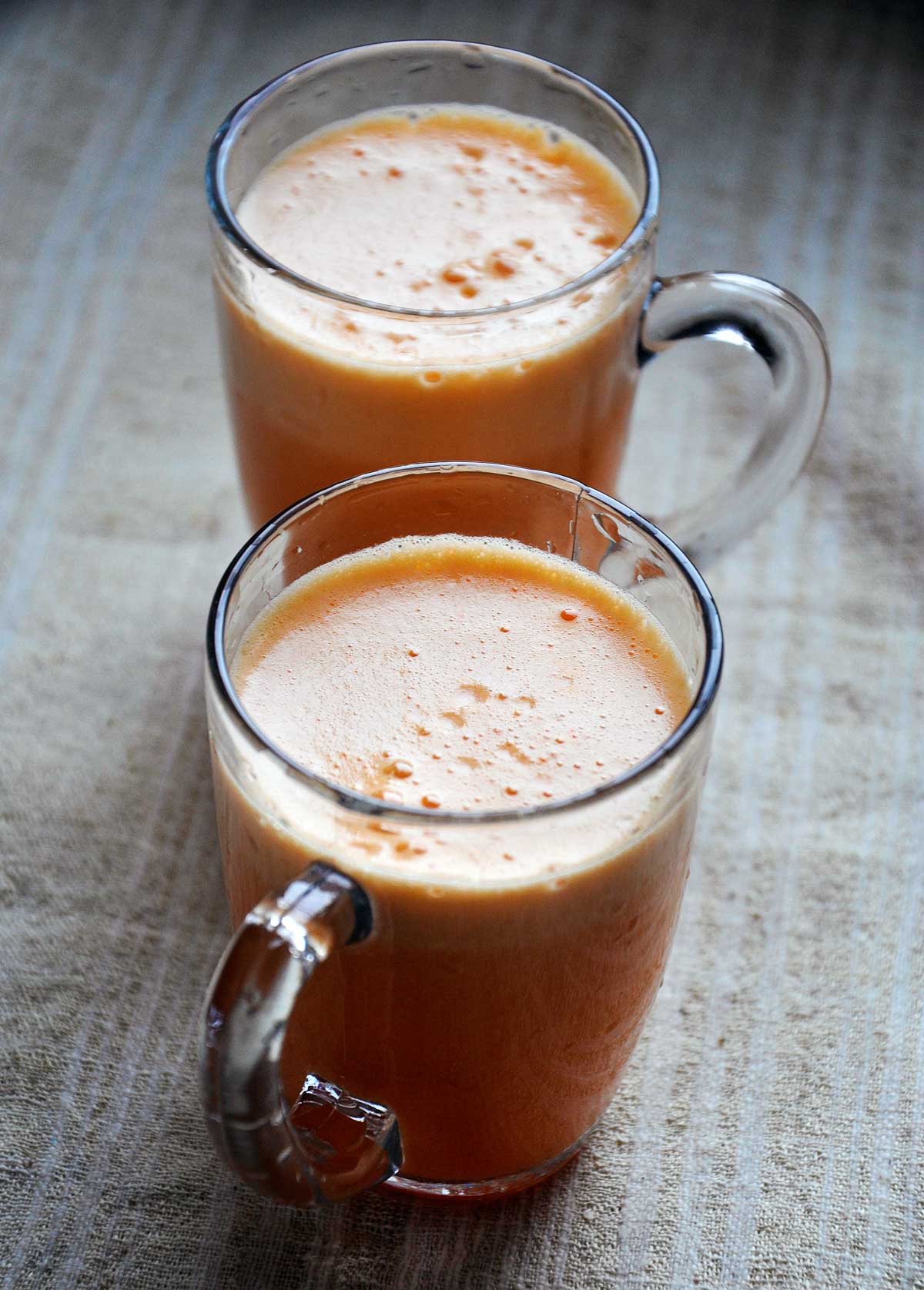 Fresh apricot juice in two clear glass mugs