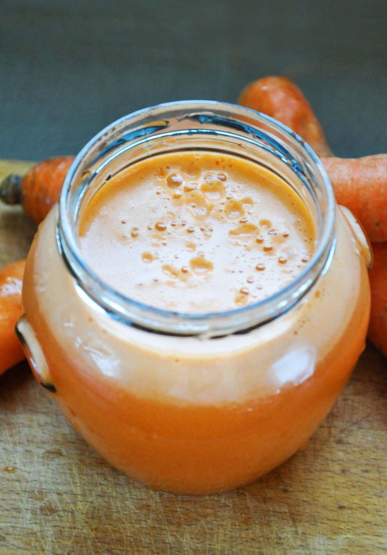 Fresh gingery carrot juice in a glass jar, overhead view