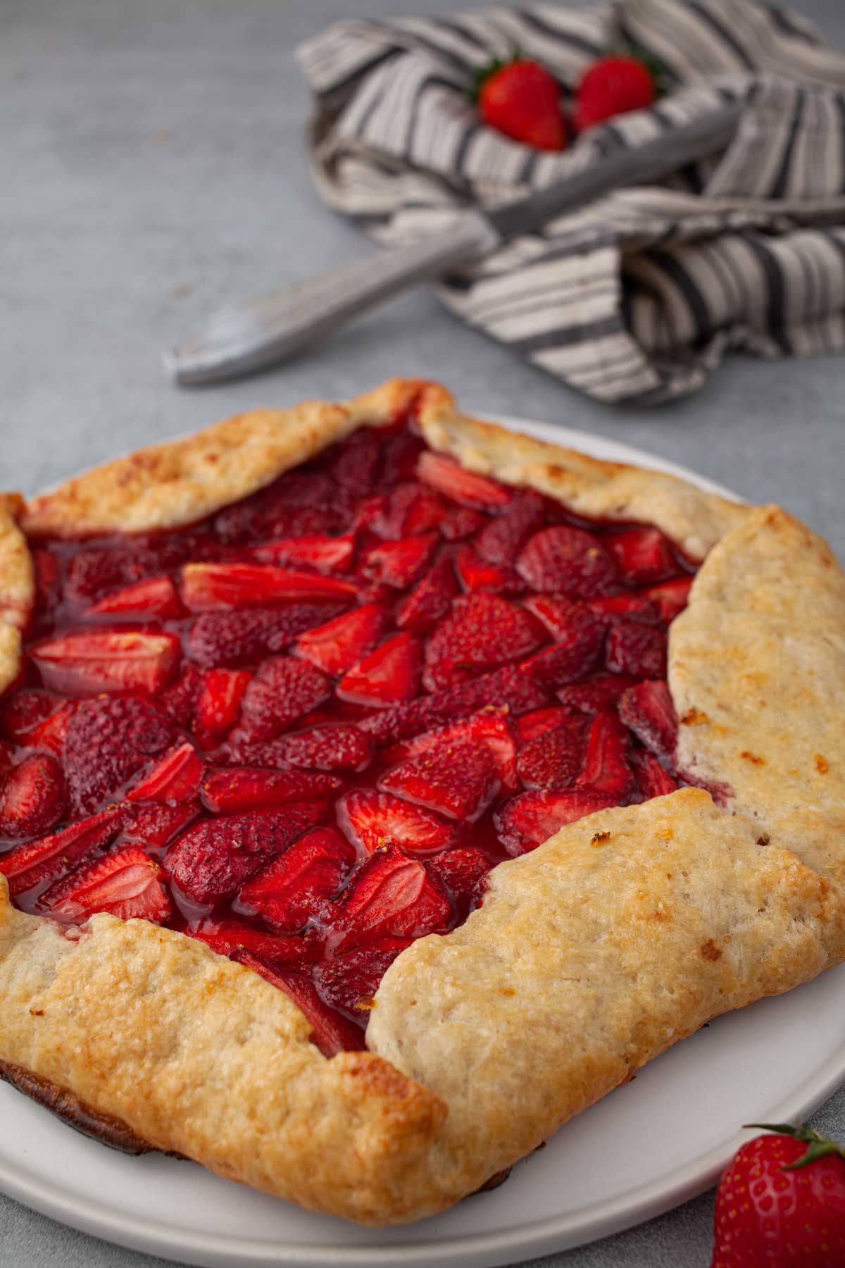 Whole rustic strawberry galette on parchment paper