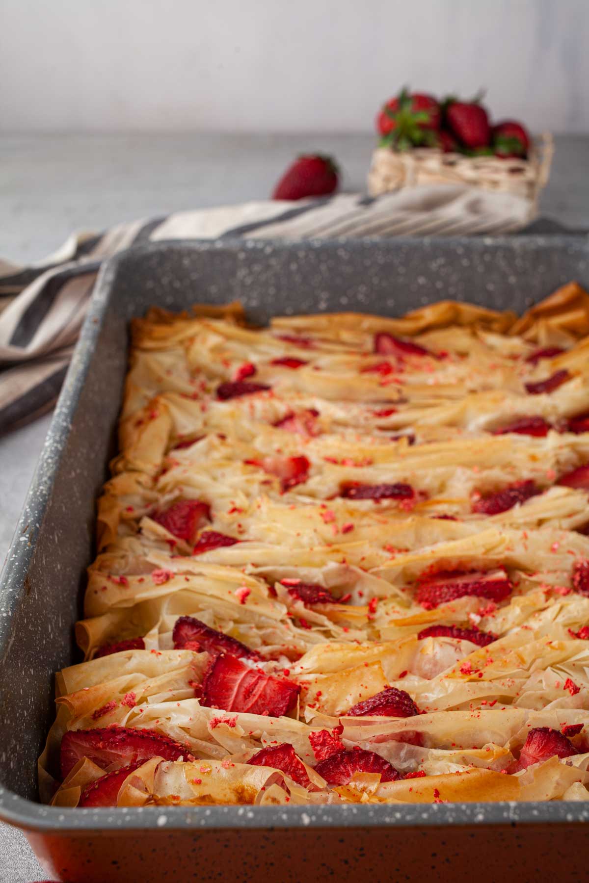 Strawberry phyllo crinkle pie cut into squares in a baking dish