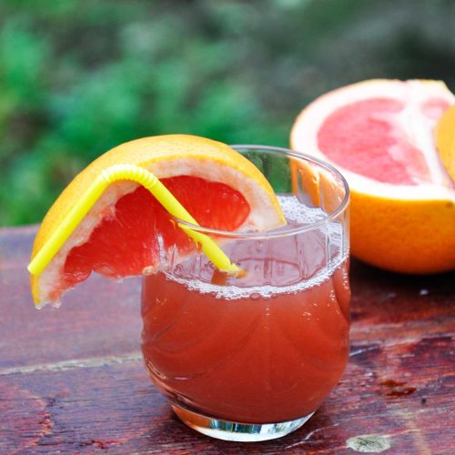 Fresh grapefruit and strawberry juice in a glass with a grapefruit wedge