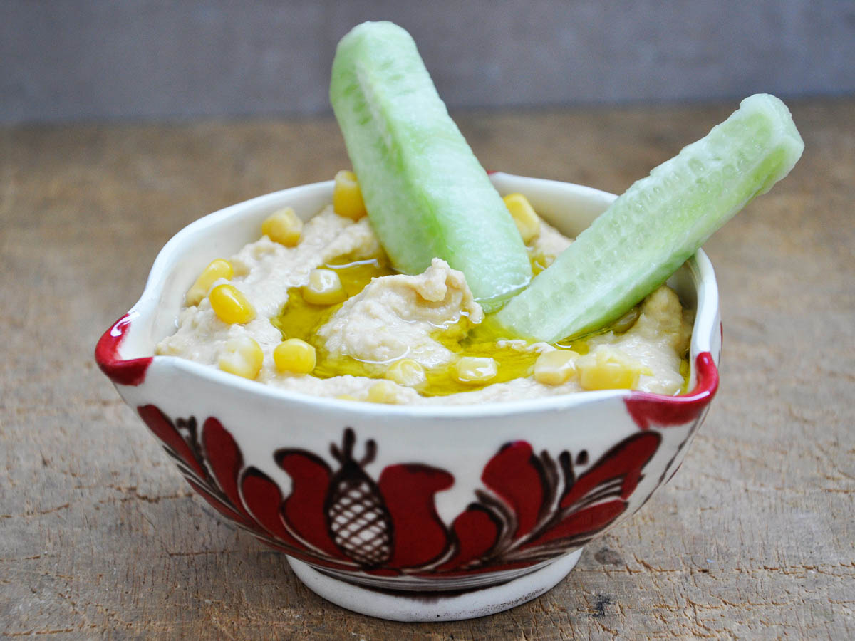 Sweet corn hummus dip served with vegetables and bread