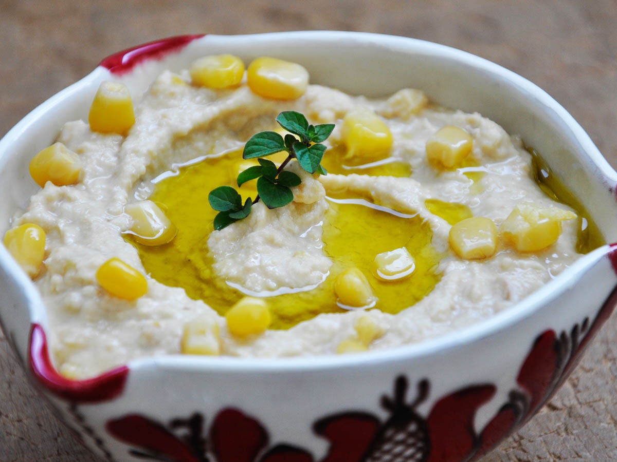 Creamy sweet corn hummus topped with corn kernels
