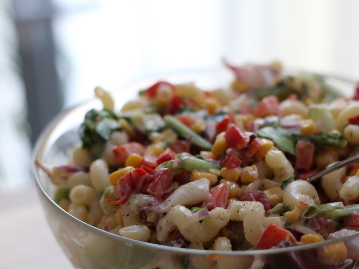 Close-up of creamy pasta salad with sweet corn and red pepper