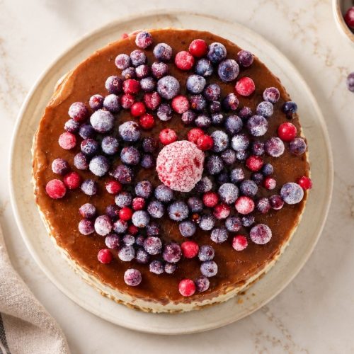 Raw vegan ice cream cake topped with frozen mixed berries