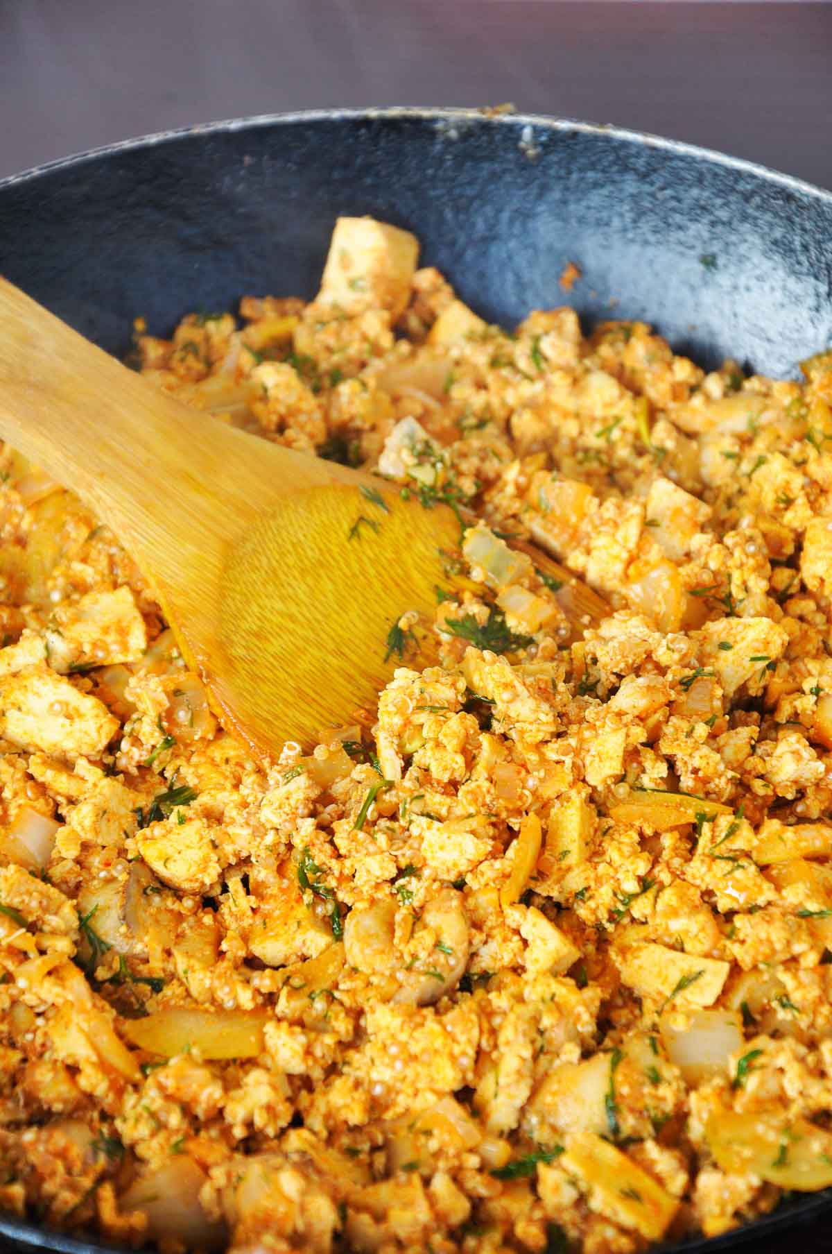 Smoky tofu scramble with mushrooms and quinoa in a skillet